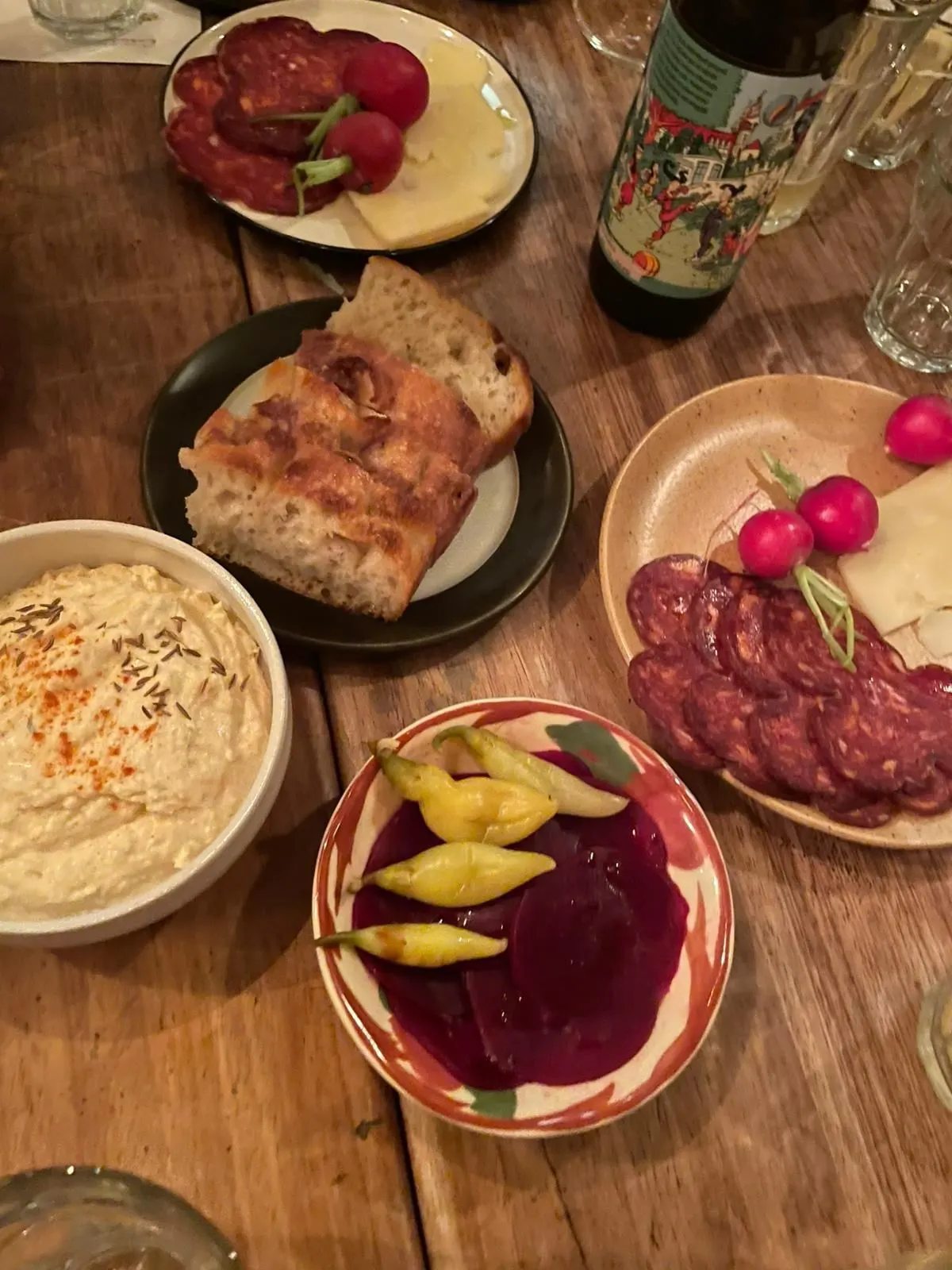 A spread of cured sausage, radishes, cheese, bread, pickles and liptauer